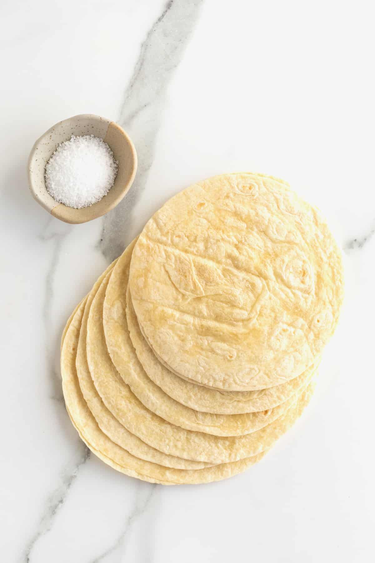 Whole flour tortillas and a  small dish of kosher salt.