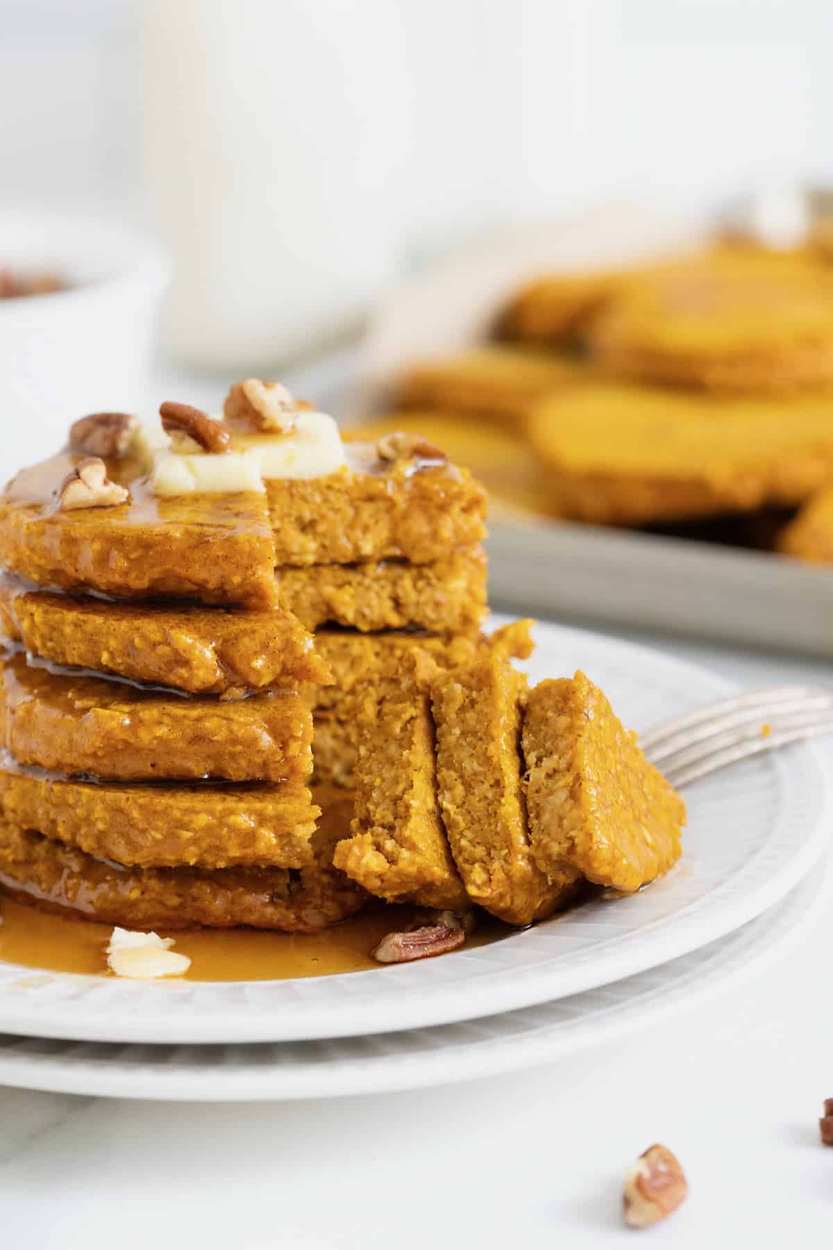 A stack of five pumpkin oatmeal blender pancakes with a bite taken out.