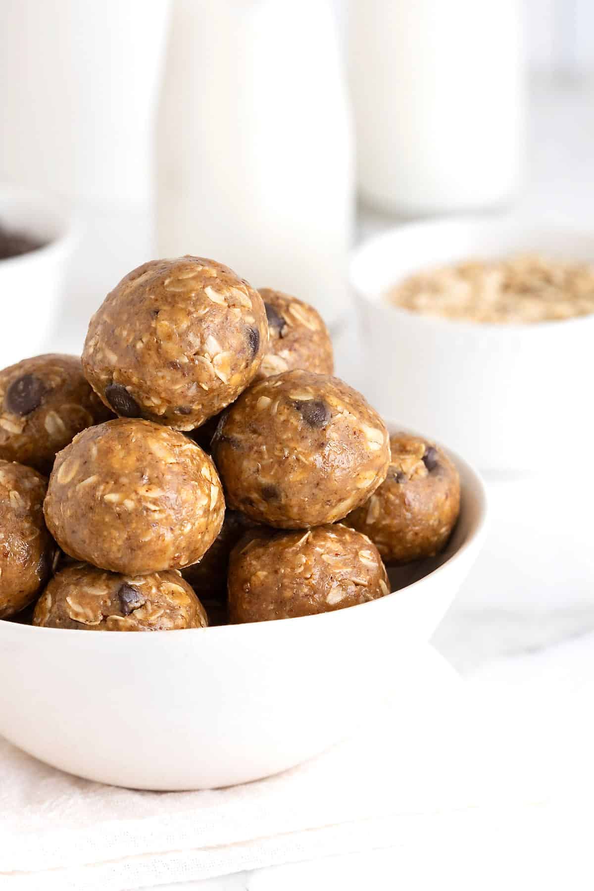 A white bowl of snack bites with chocolate chips in them.