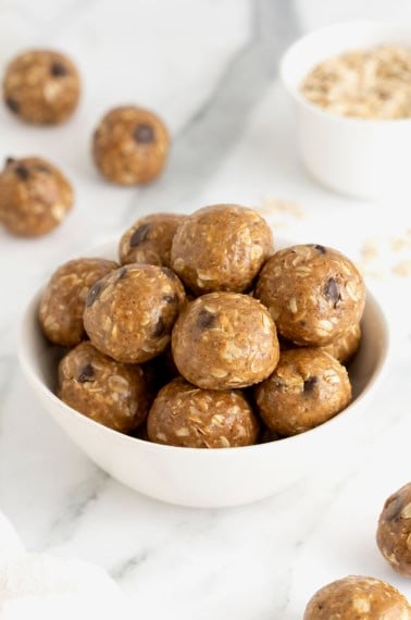 A white bowl of snack bites with chocolate chips in them.