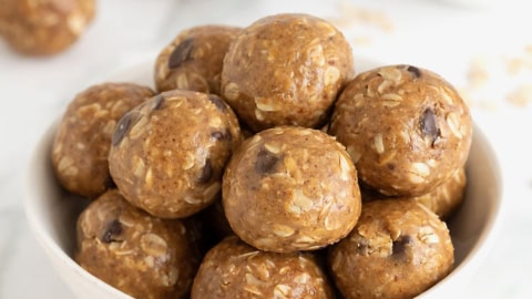 A white bowl of snack bites with chocolate chips in them.