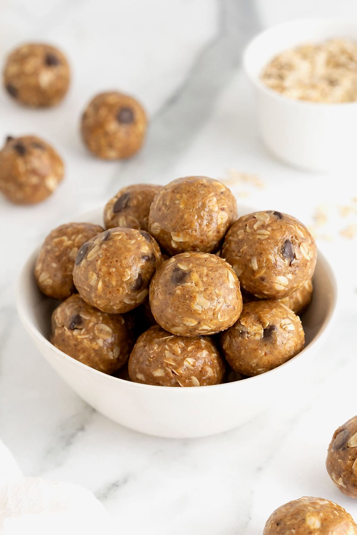 A white bowl of snack bites with chocolate chips in them.