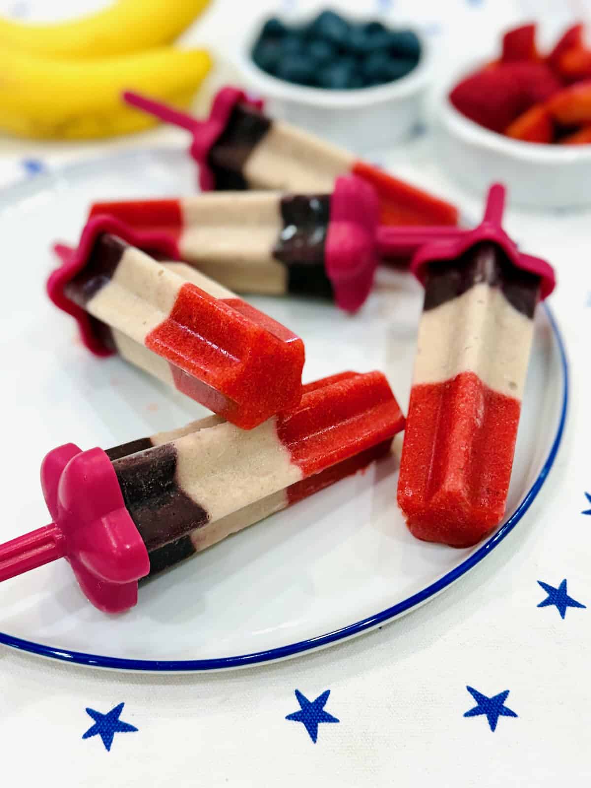 Five star-shaped fruit pops on a white serving plate.