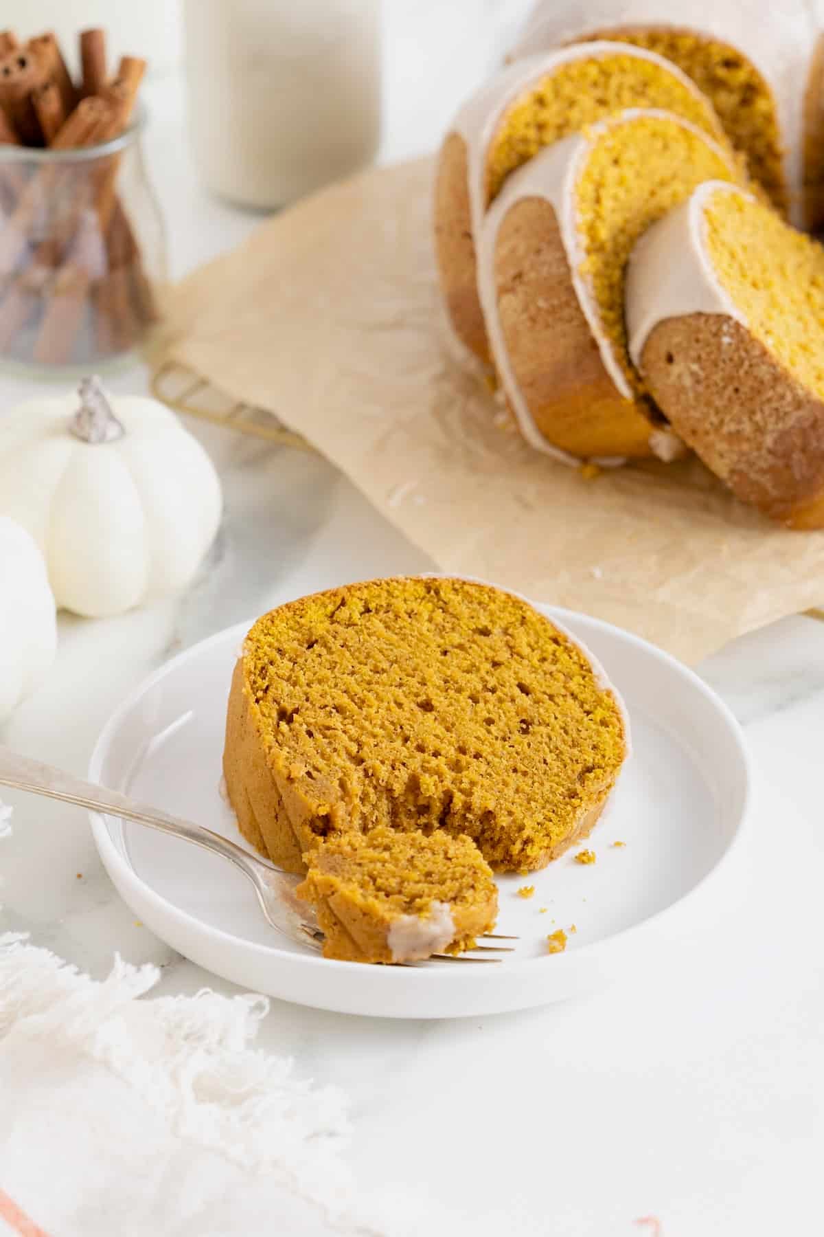 A slice of chai spiced pumpkin pound cake on a white plate.