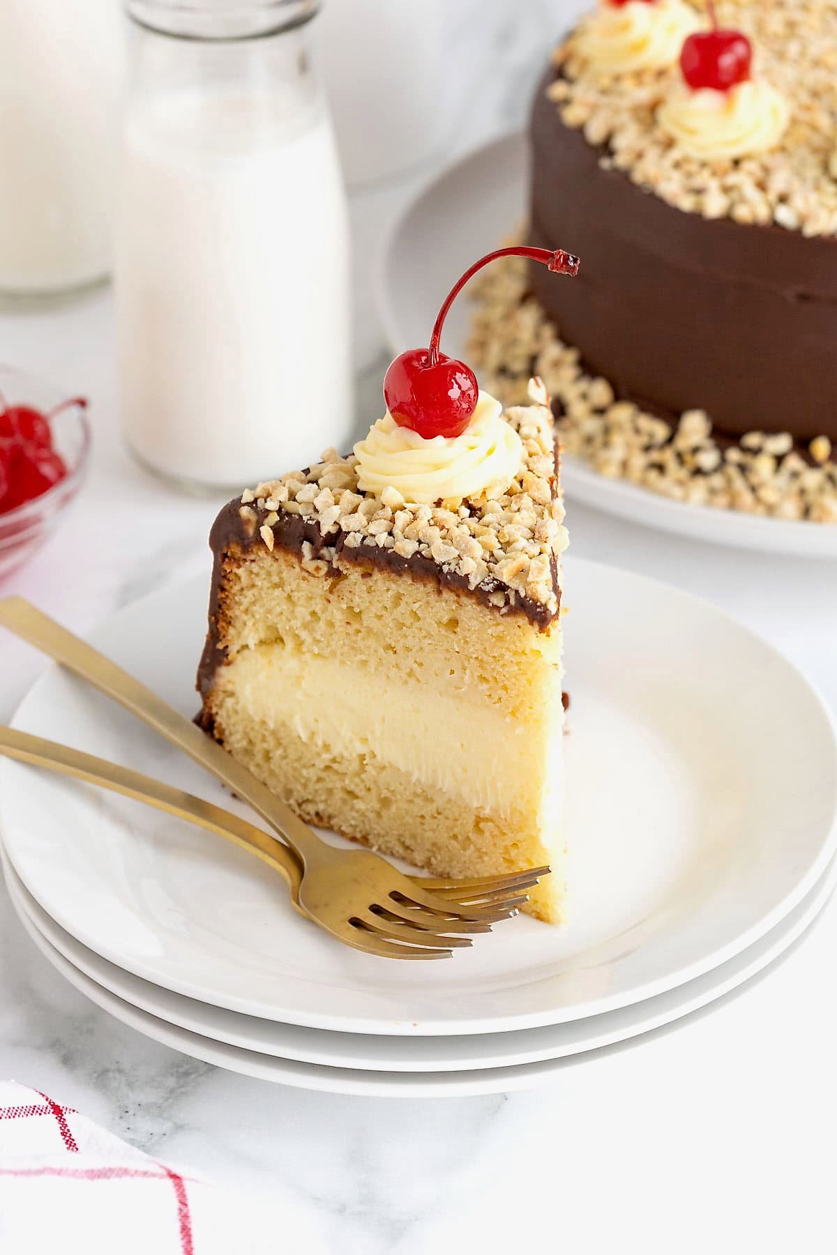 A slice of hot fudge sundae cake on a white plate with two forks.