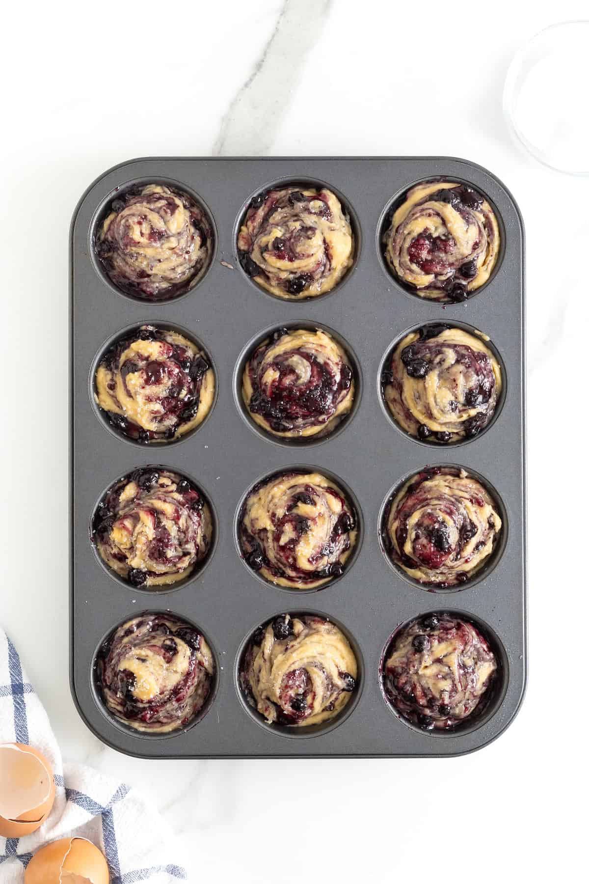 Blueberry preserves swirled into the top of muffin batter.