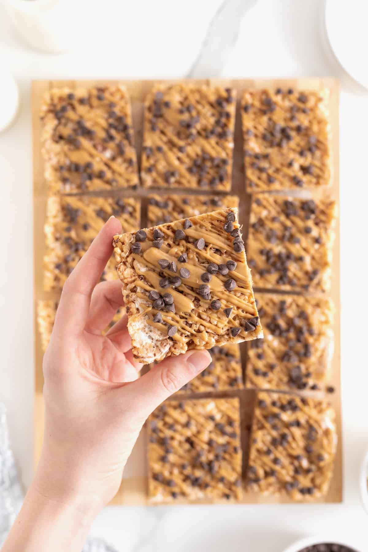 A hand holding a peanut butter Rice Krispies treat.