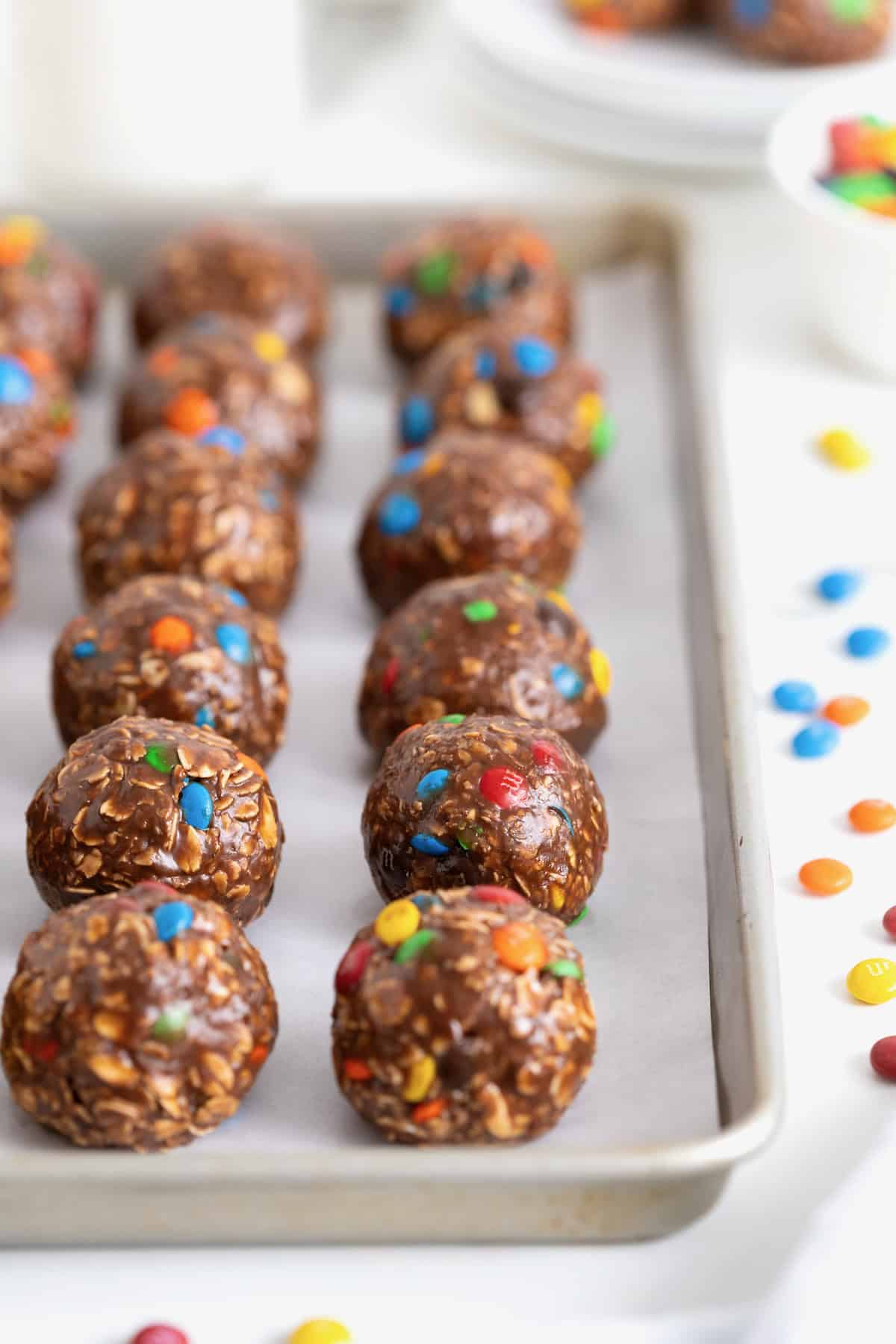 Twelve Nutella m&M bites on a parchment lined baking sheet.
