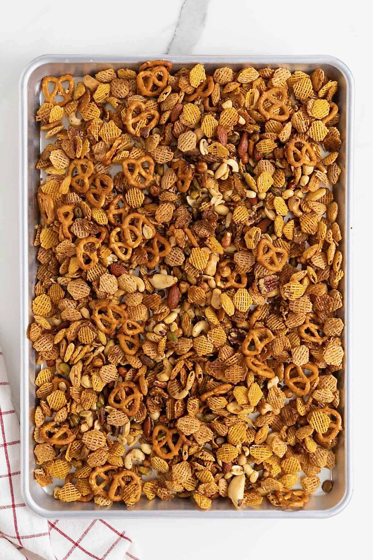 Snack mix on an aluminum baking sheet.