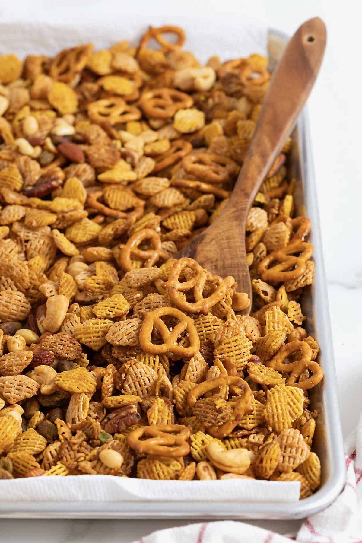 Snack mix on an aluminum baking sheet.