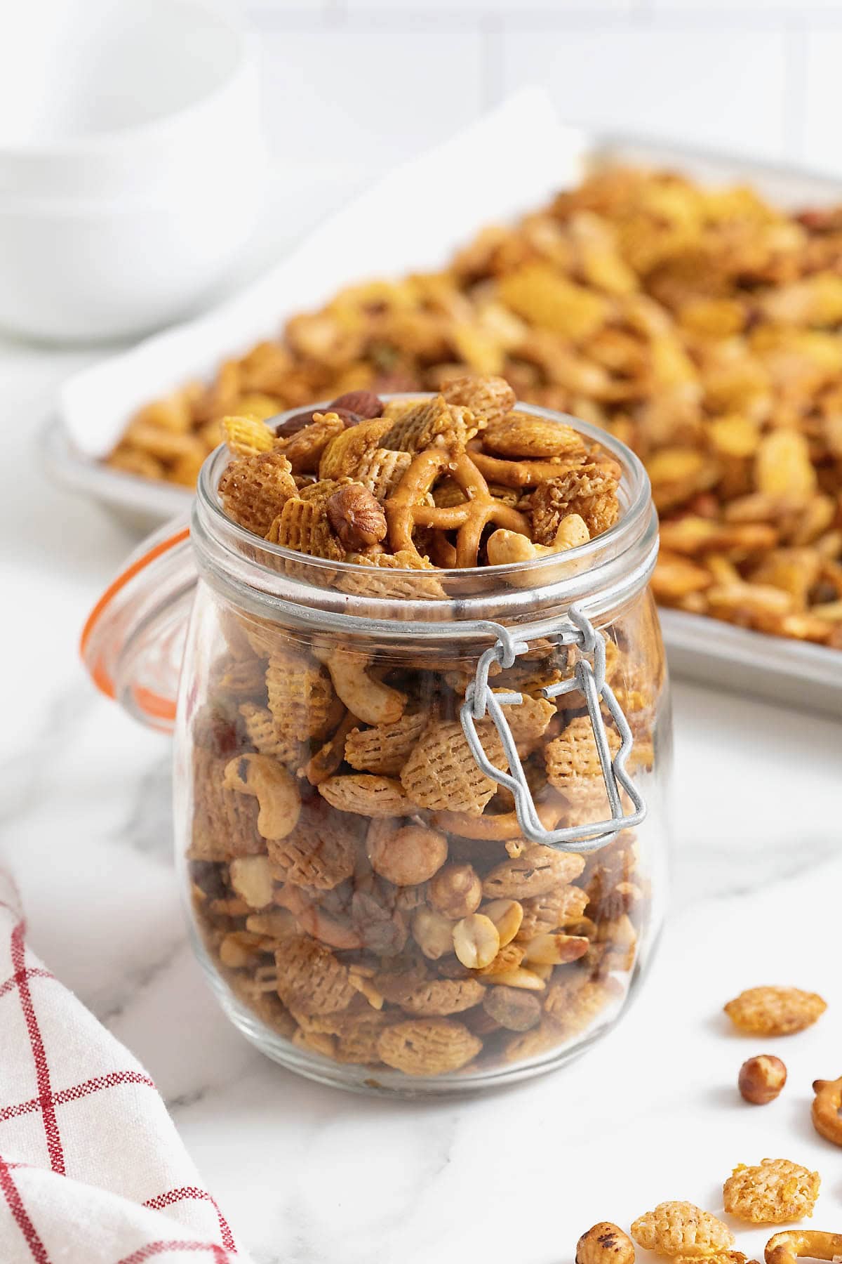 Snack mix in a jar on a white marble counter.