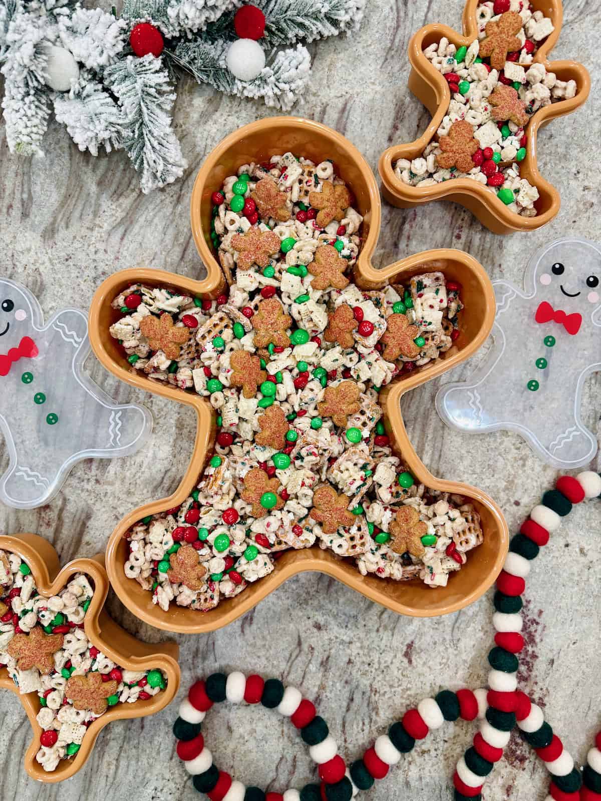 A gingerbread man shaped container filled with snack mix.