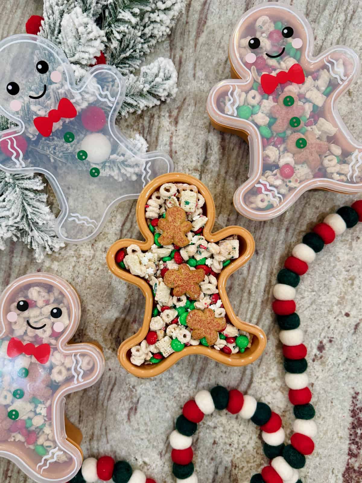 A gingerbread shaped container filled with snack mix.