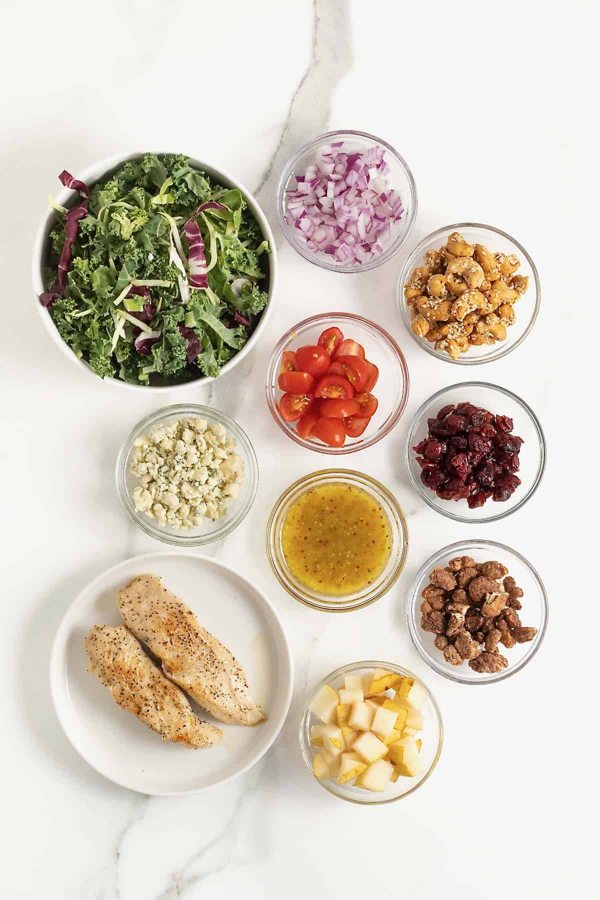 Ingredients to make my favorite lunch salad in small glass dishes on a white marble counter.