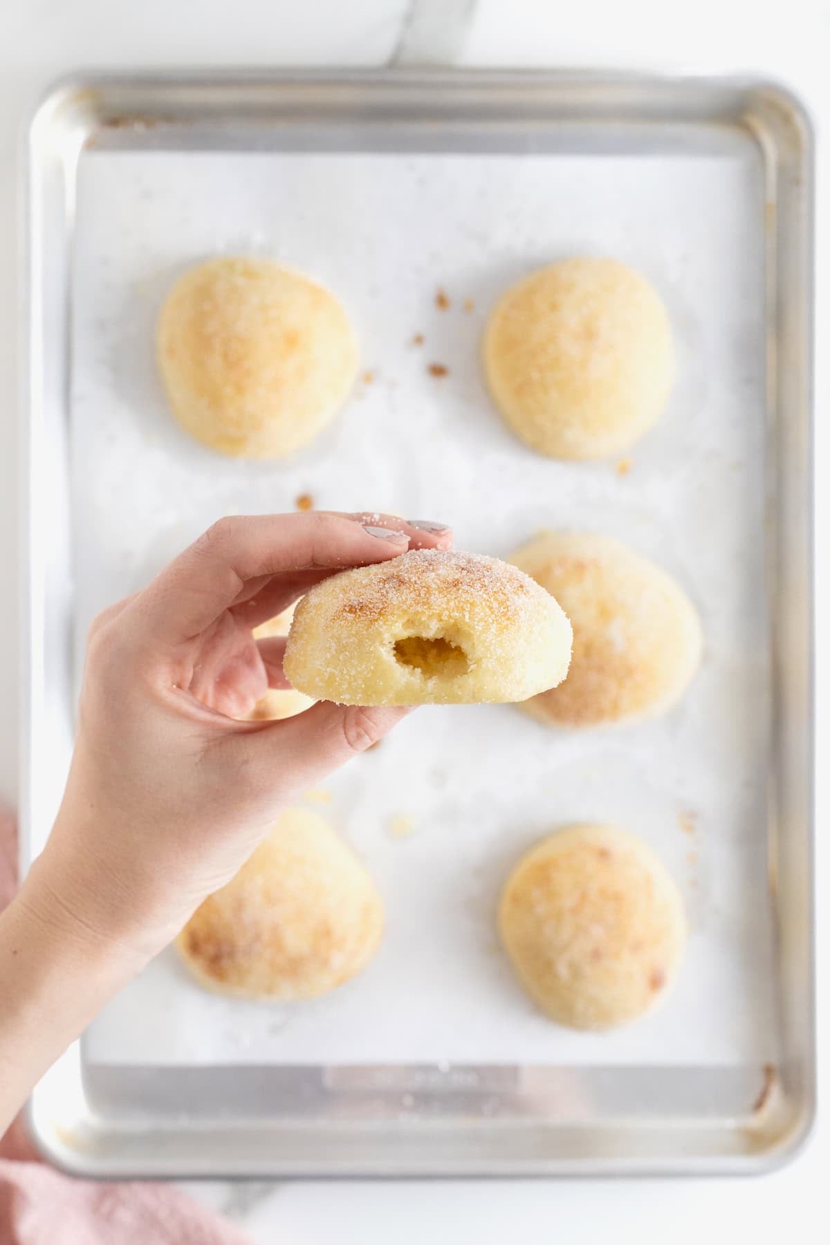 A baked donut with a hole poked in it for filling.