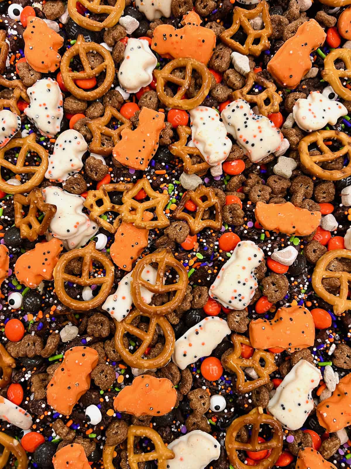 A pile of Halloween snack mix on a rimmed baking sheet.