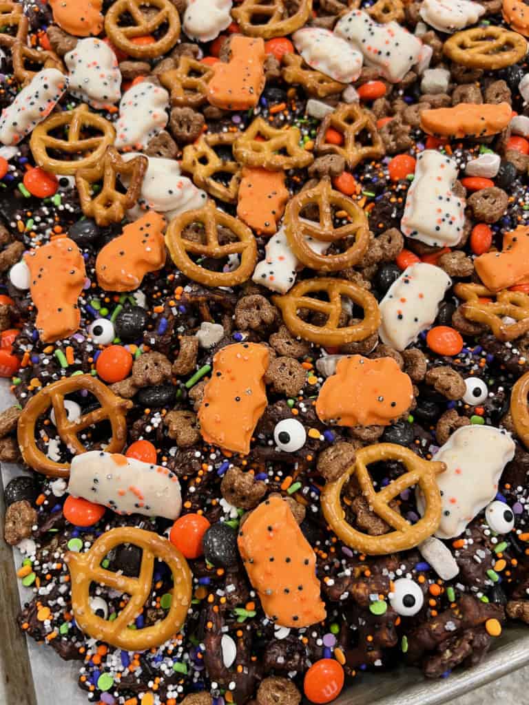 A pile of Halloween snack mix on a rimmed baking sheet.