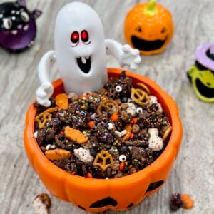 Halloween snack mix in a festive orange jack-o-lantern bowl with a ghost figure.