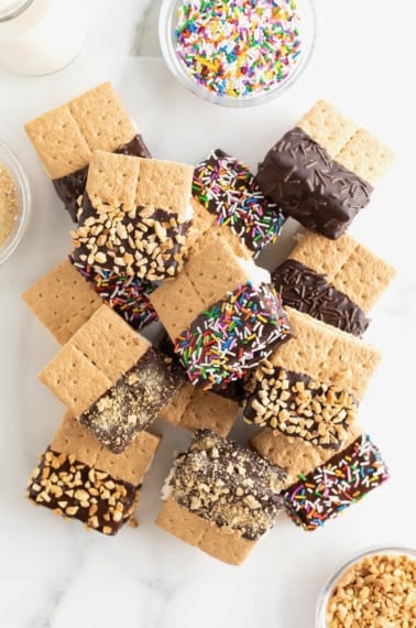 A pile of graham cracker ice cream sandwiches that have been dipped halfway in chocolate.