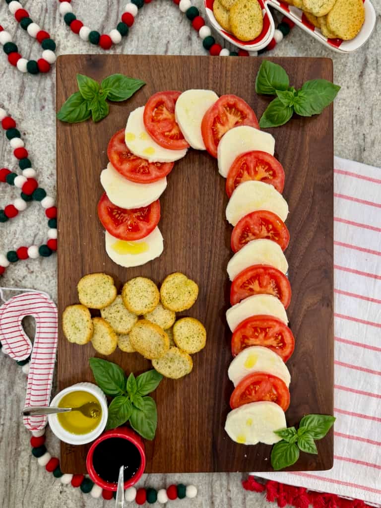 A candy cane caprese board made of sliced tomatoes and mozzarella.
