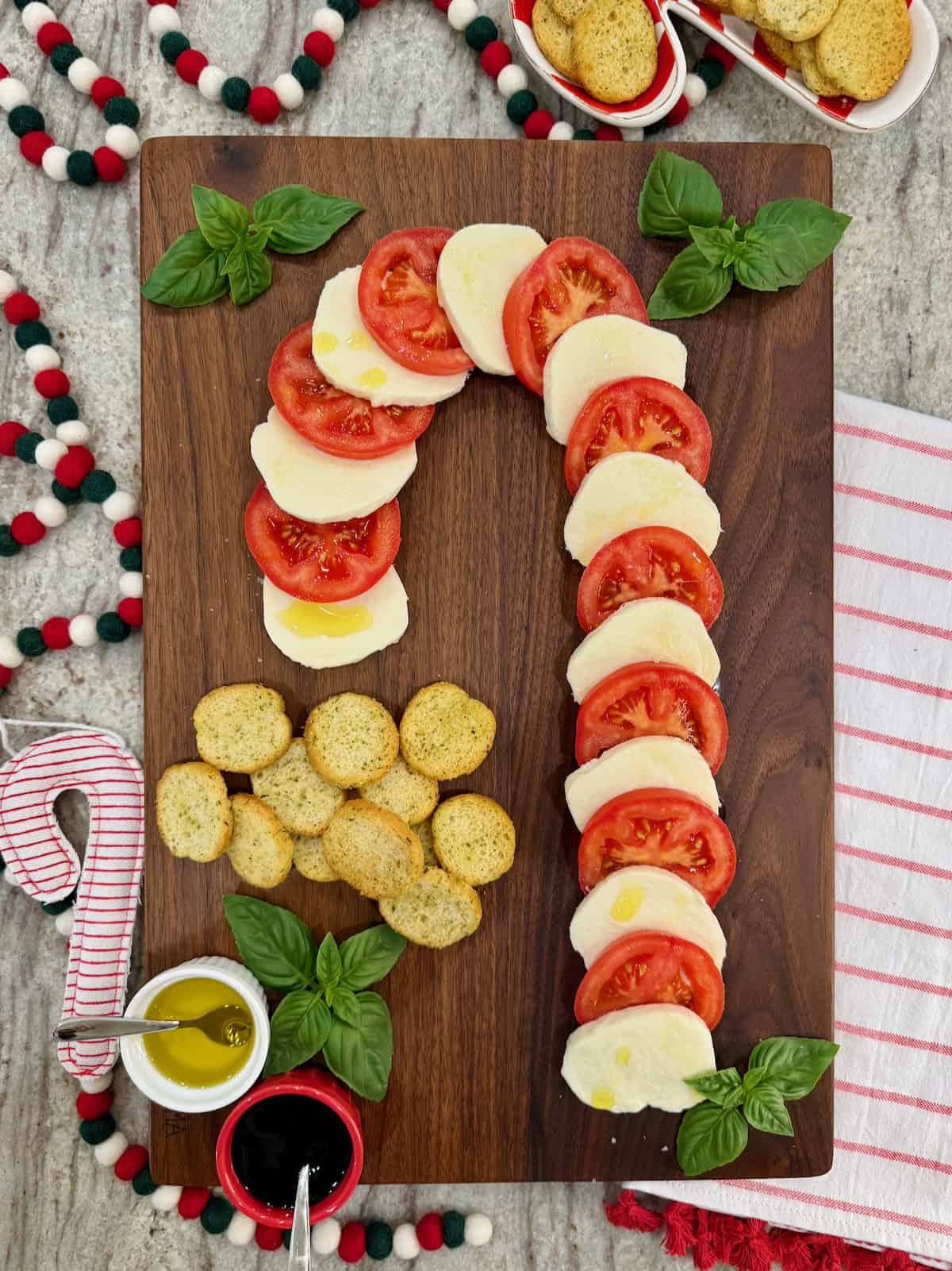 A candy cane caprese board made of sliced tomatoes and mozzarella.
