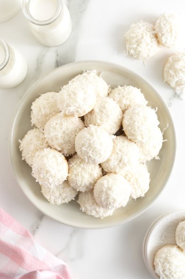 A platter of cookies coated in white chocolate and coconut.