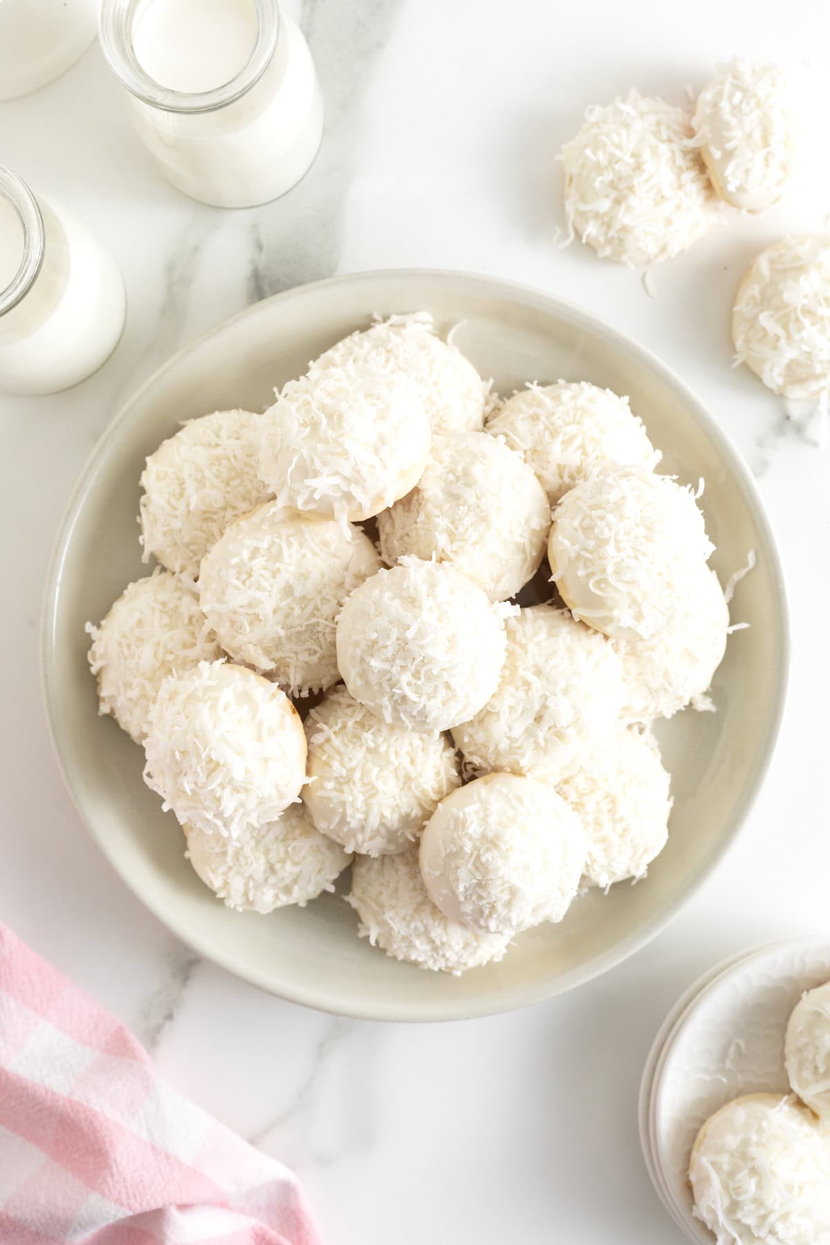 A platter of cookies coated in white chocolate and coconut.