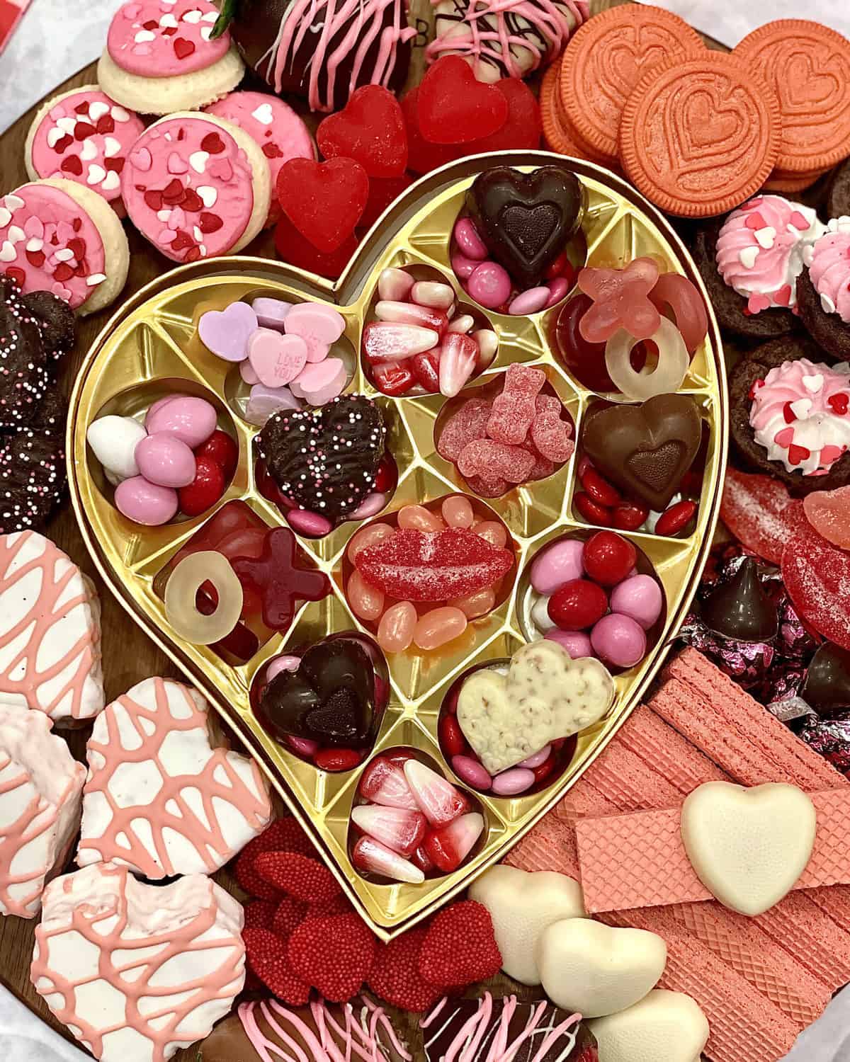 Dessert Board with heart-shaped cakes, conversation hearts, M&Ms, pink and white sugar cookies