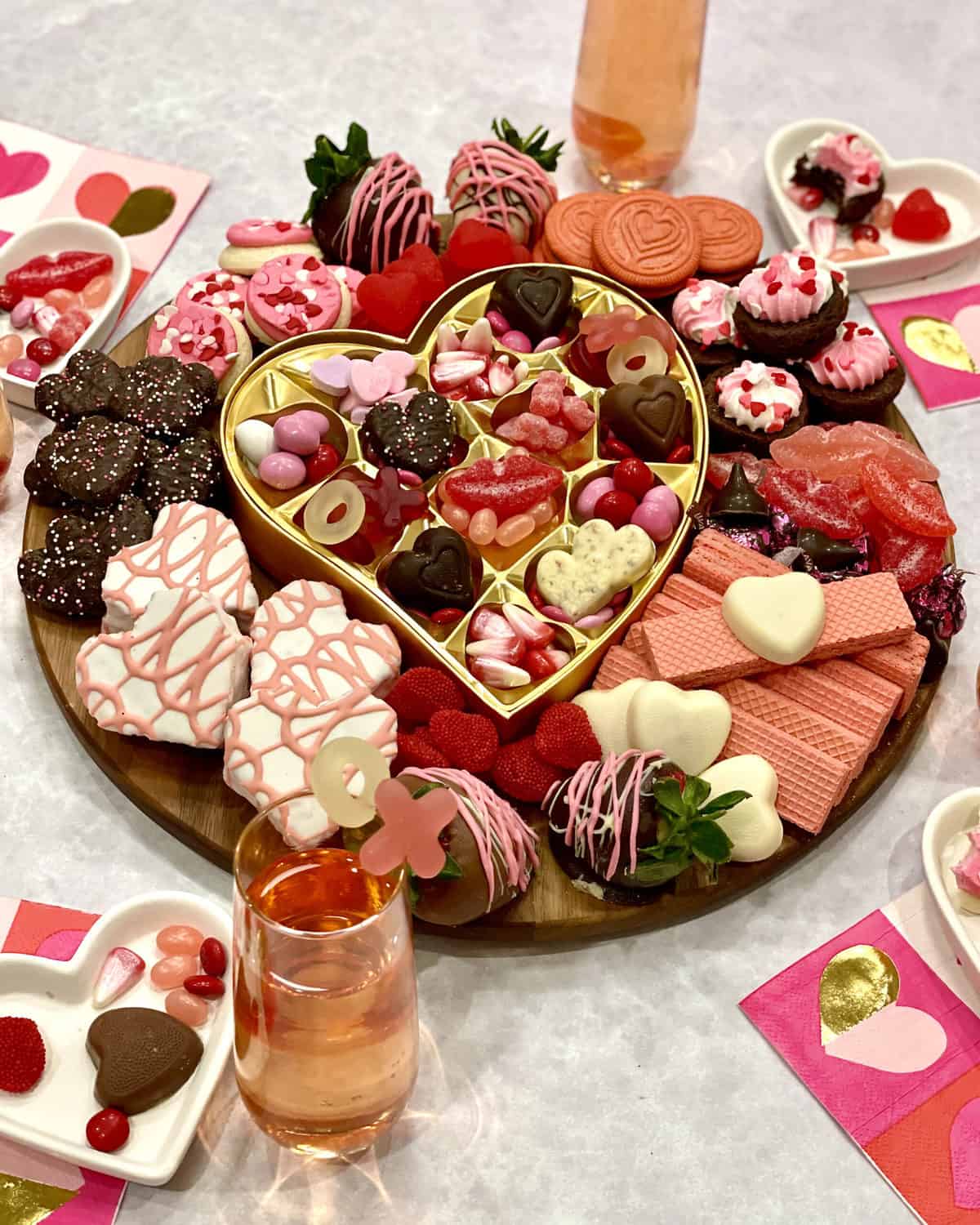 Galentine's Day Dessert Board with heart-shaped cakes, conversation hearts, M&Ms, pink and white sugar cookies