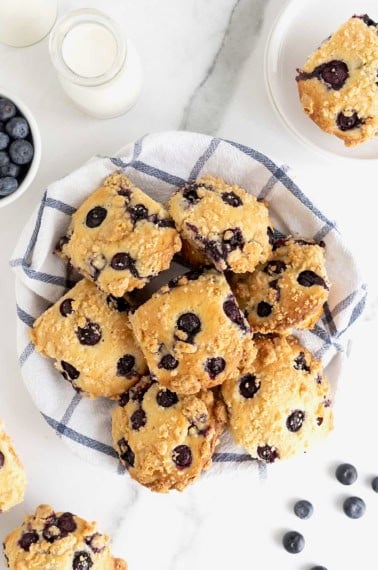 A basket full of blueberry streusel muffins.