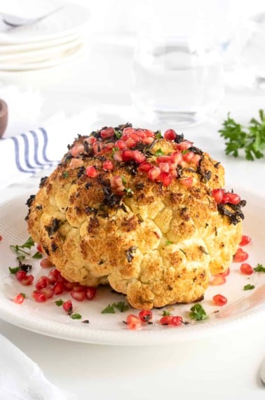 Whole Roasted Garlic and Herb Cauliflower with Pomegranate Seeds by The BakerMama