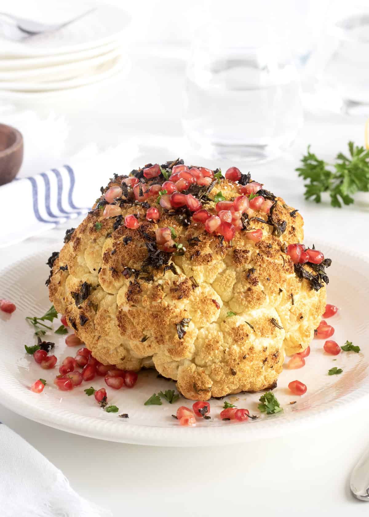 Whole Roasted Garlic and Herb Cauliflower with Pomegranate Seeds by The BakerMama