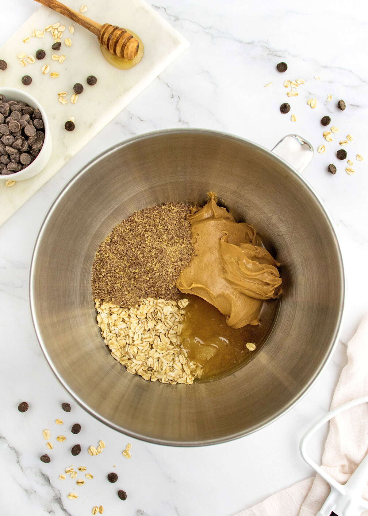 Ingredients to make no-bake energy bites in a stainless steel mixing bowl.