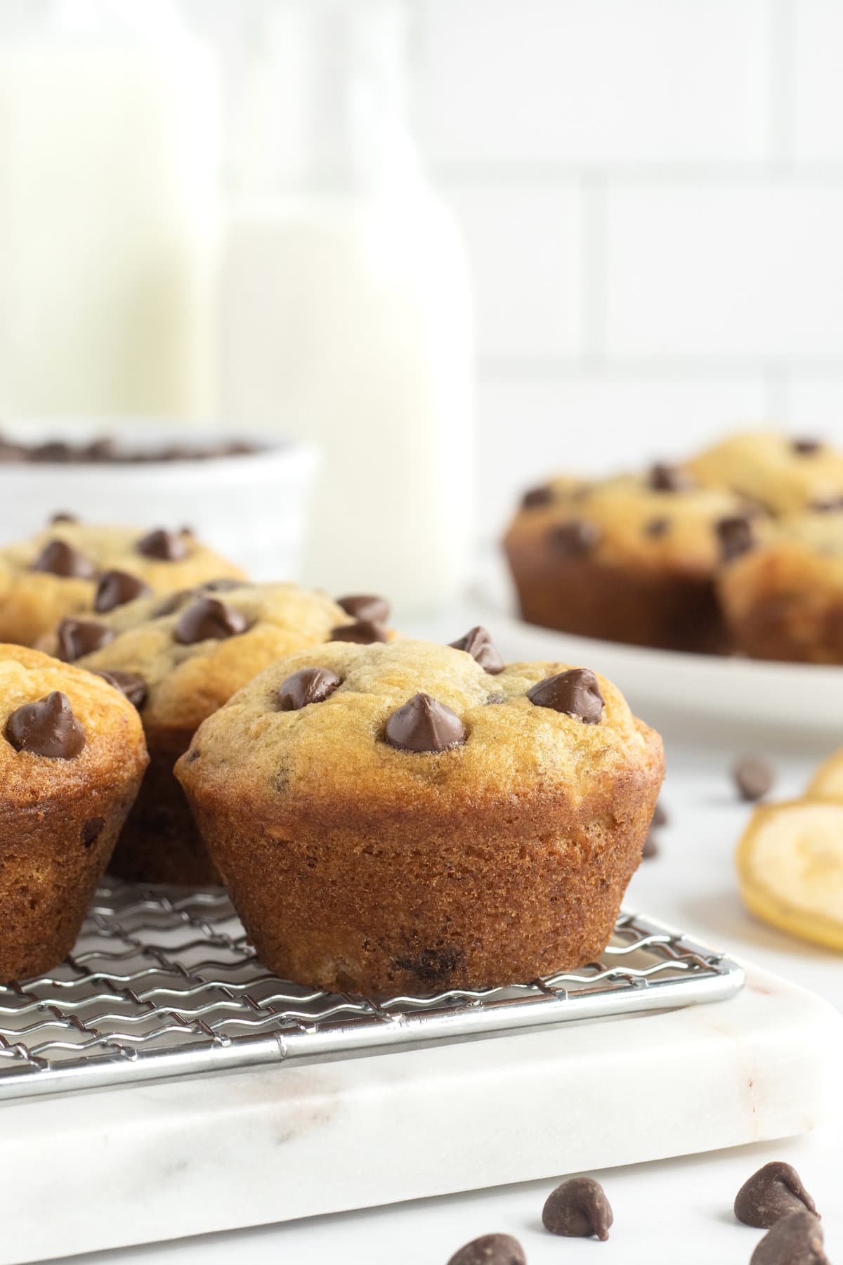 Six banana chocolate chip muffins on a wire rack.