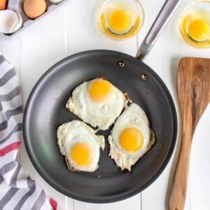 Three fried eggs in a nonstick skillet.