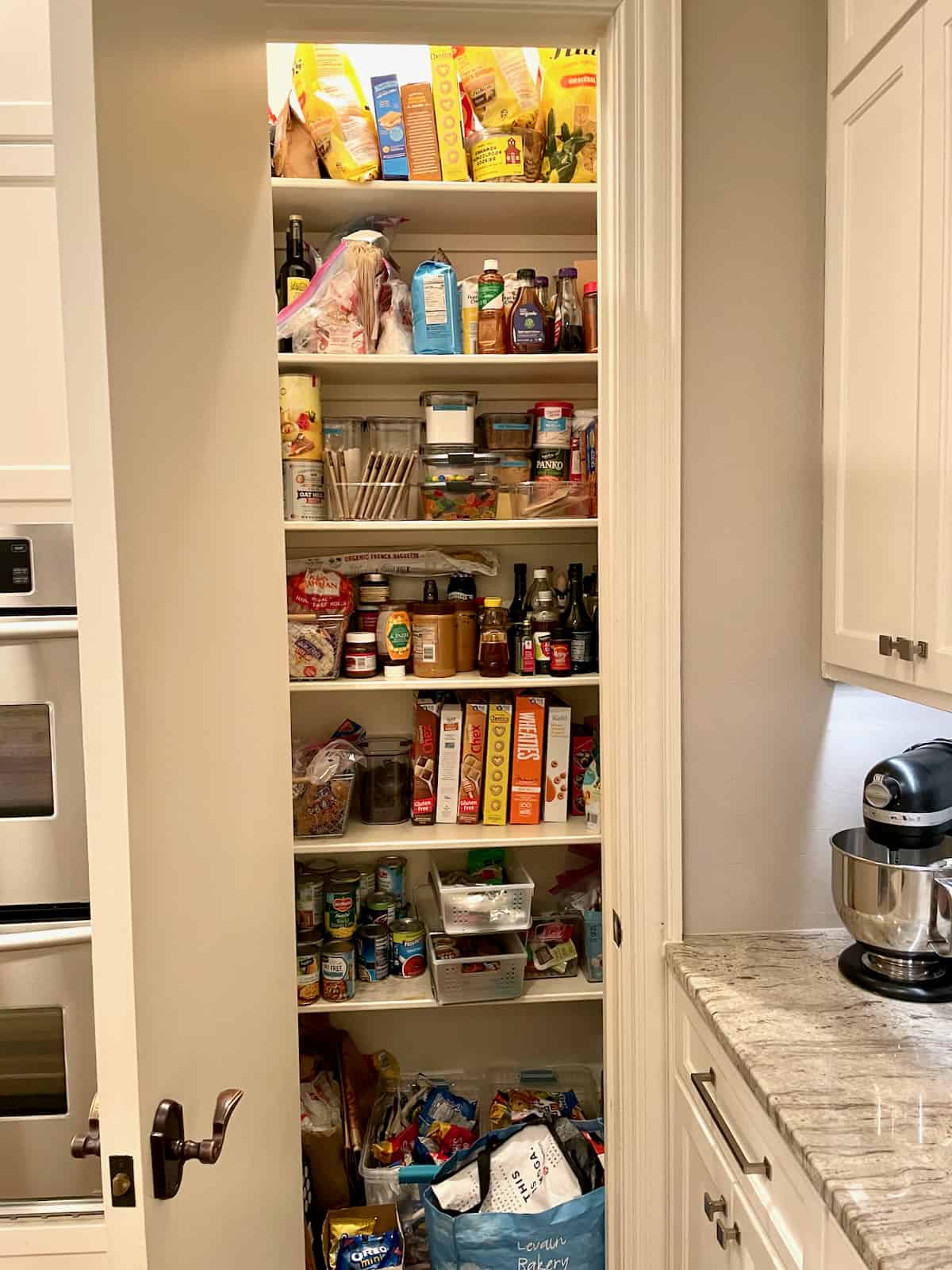 Pantry closet with shelves of packaged foods.