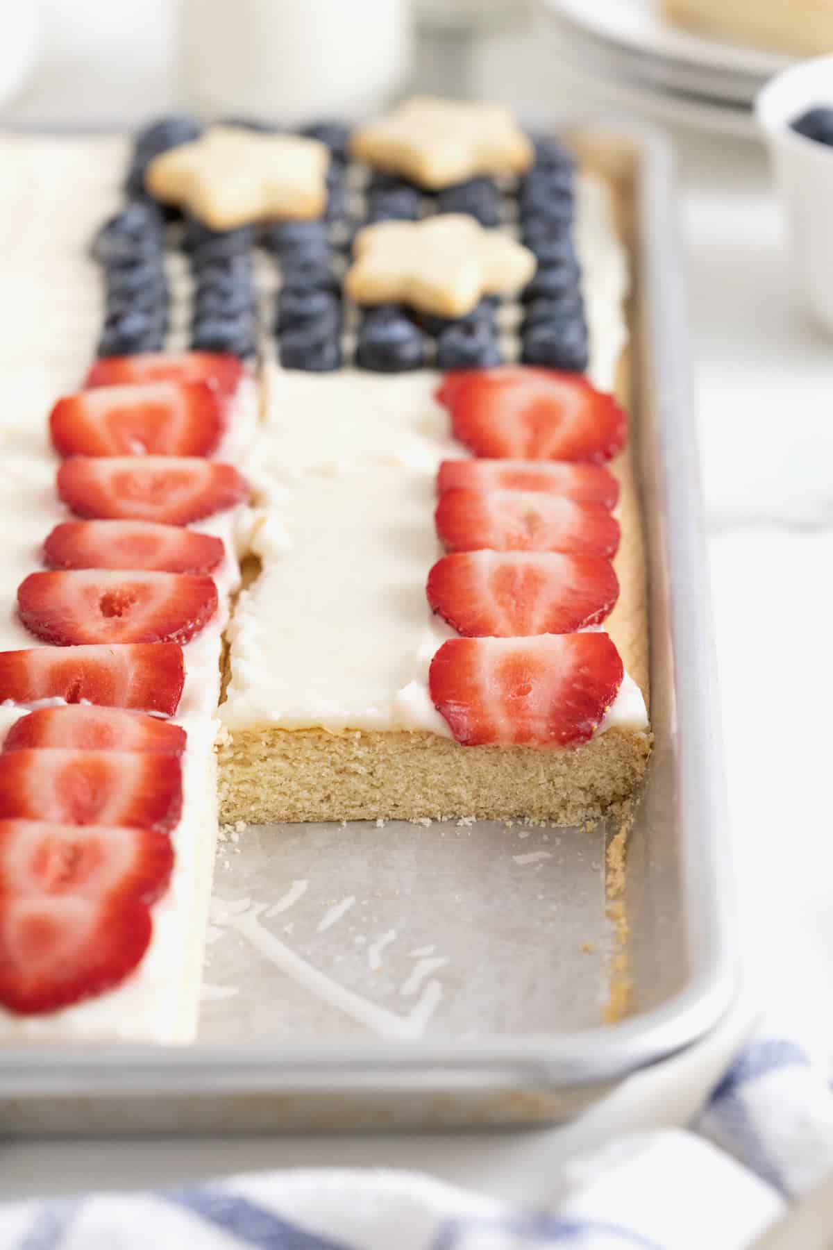 An American flag fruit pizza with a serving removed.