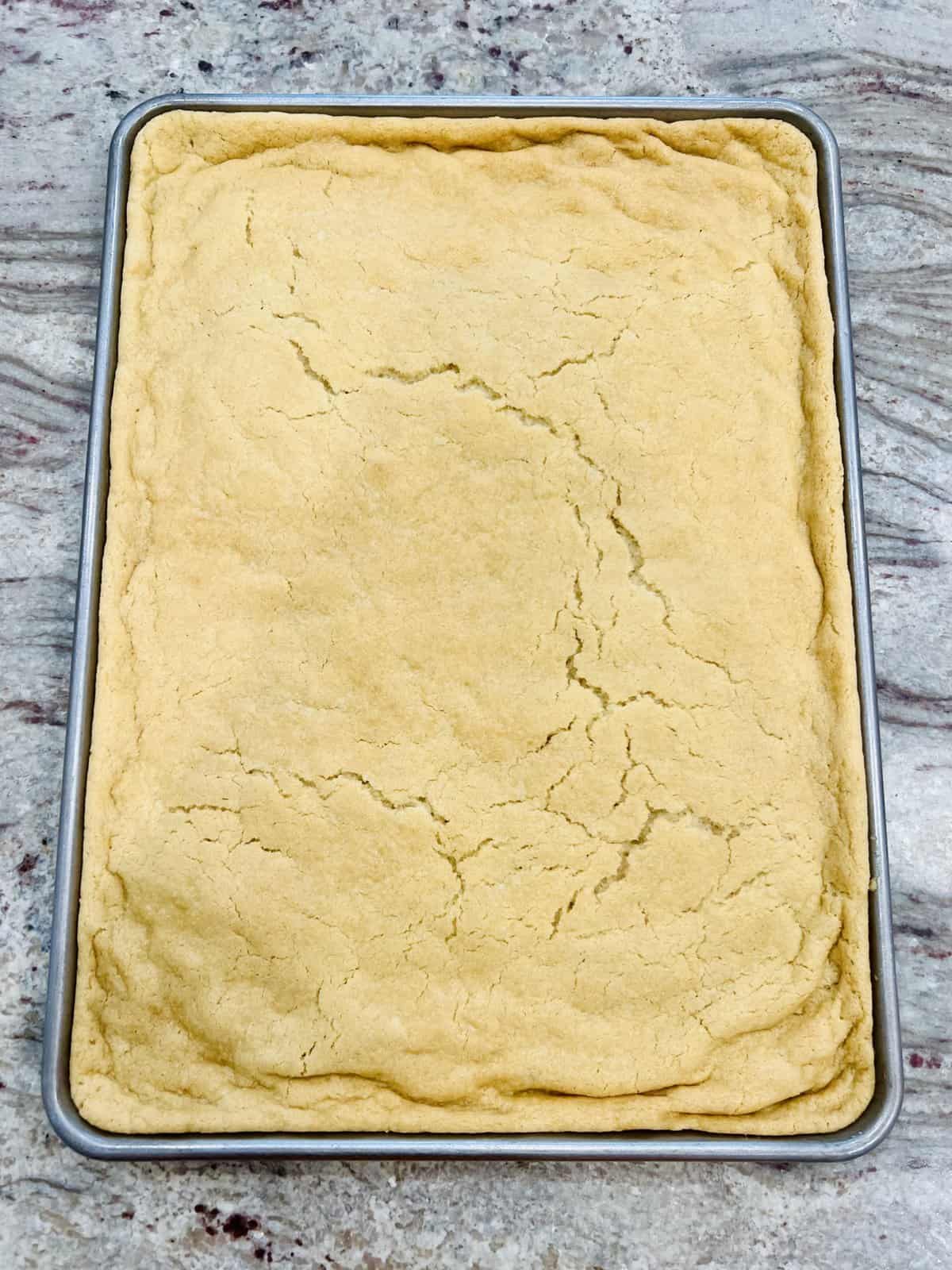 A sheet pan sugar cookie baked in a rimmed cookie sheet.