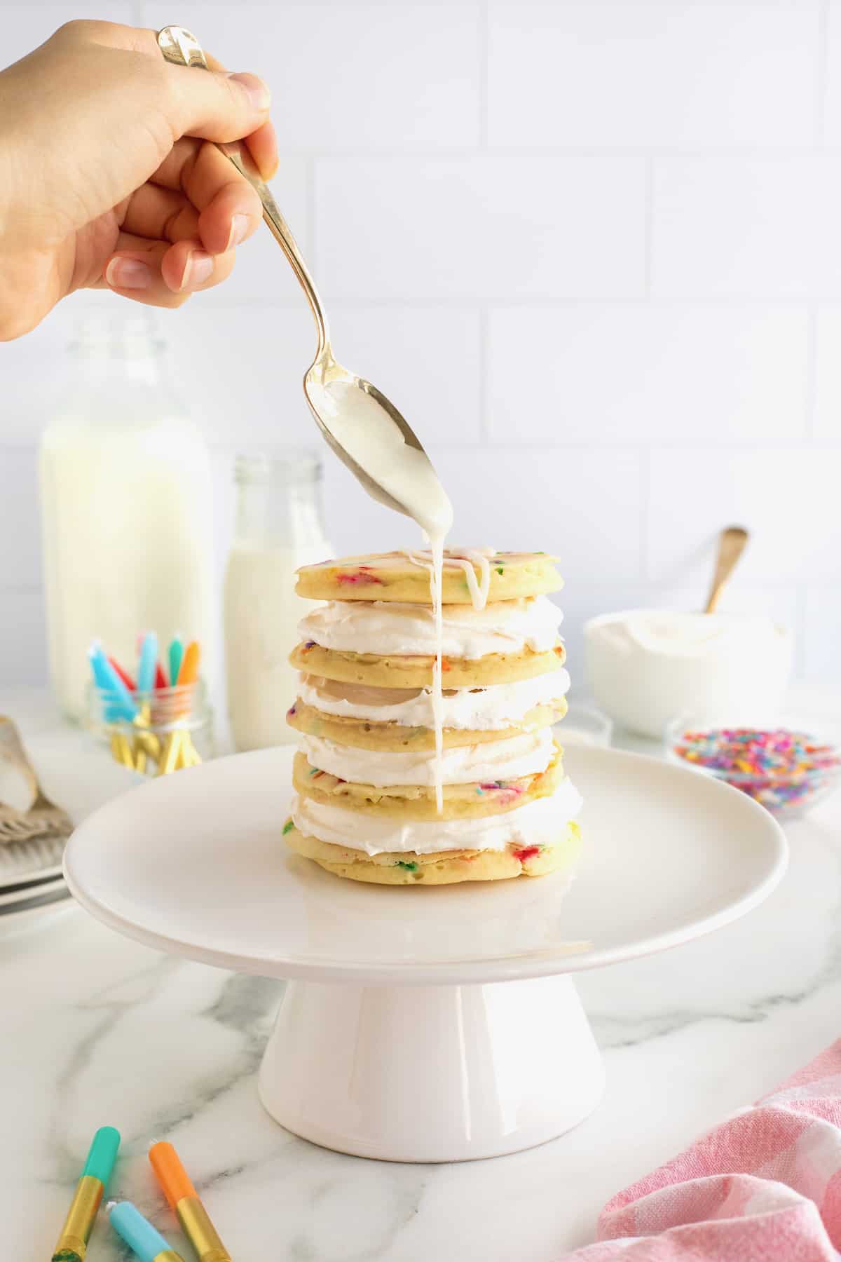 A layer cake made from confetti pancakes drizzled with simple icing.