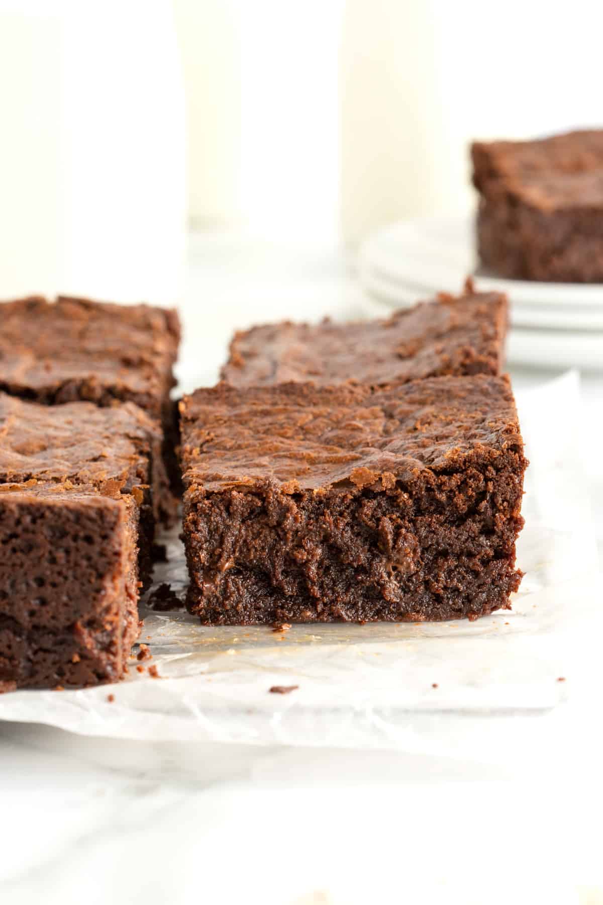 Moist and chewy brownies on a parchment lined cooling rack.