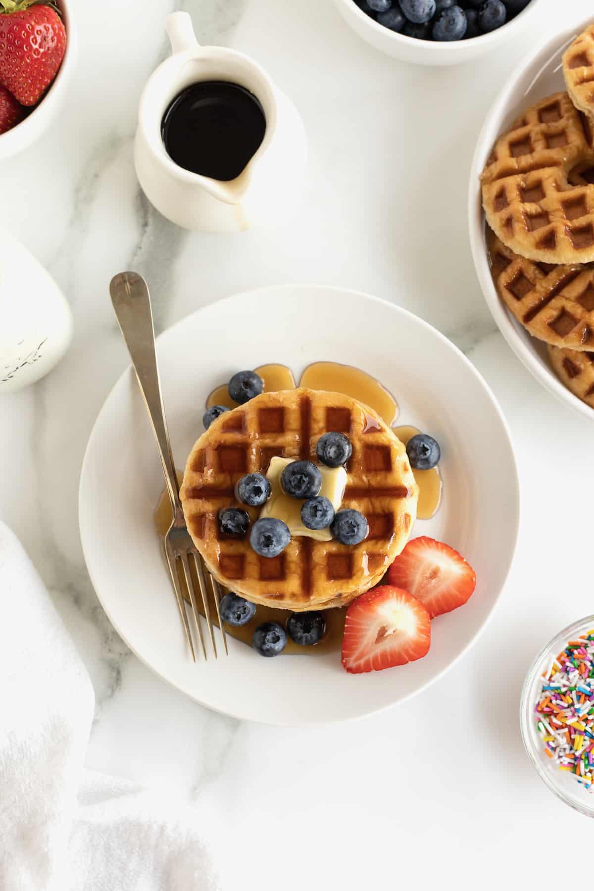 Waffles made from glazed donuts with butter, blueberries and maple syrup.