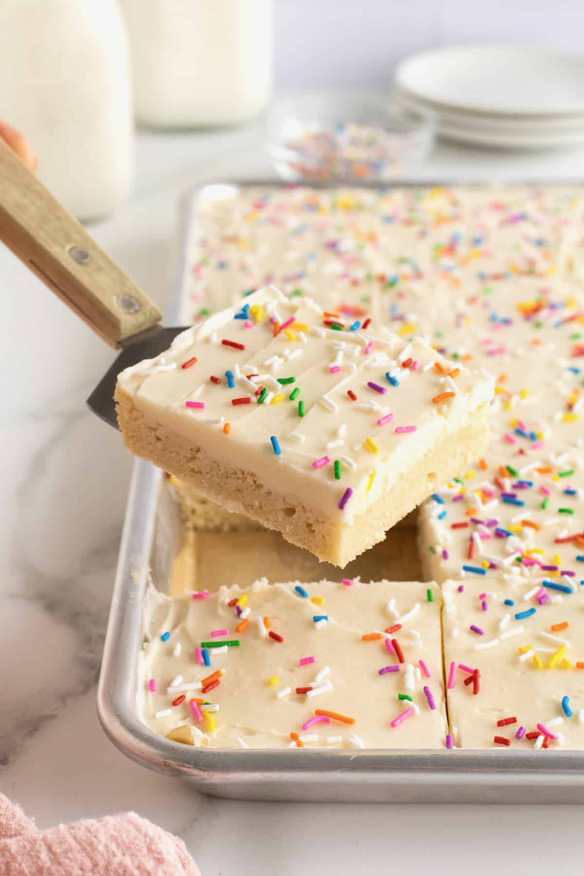 A frosted sugar cookie bar on a spatula.