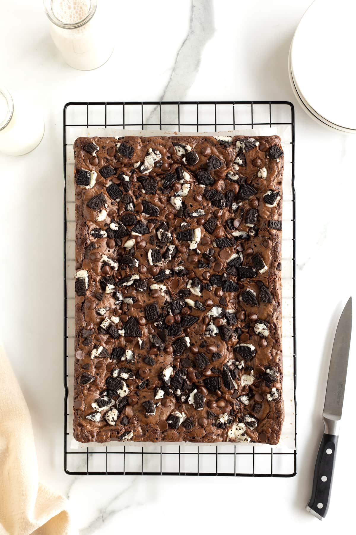 Three layer brownies on a parchment lined cooling rack.