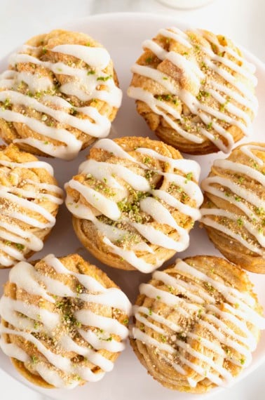 7 key lime cruffins arranged on a large white round serving platter.