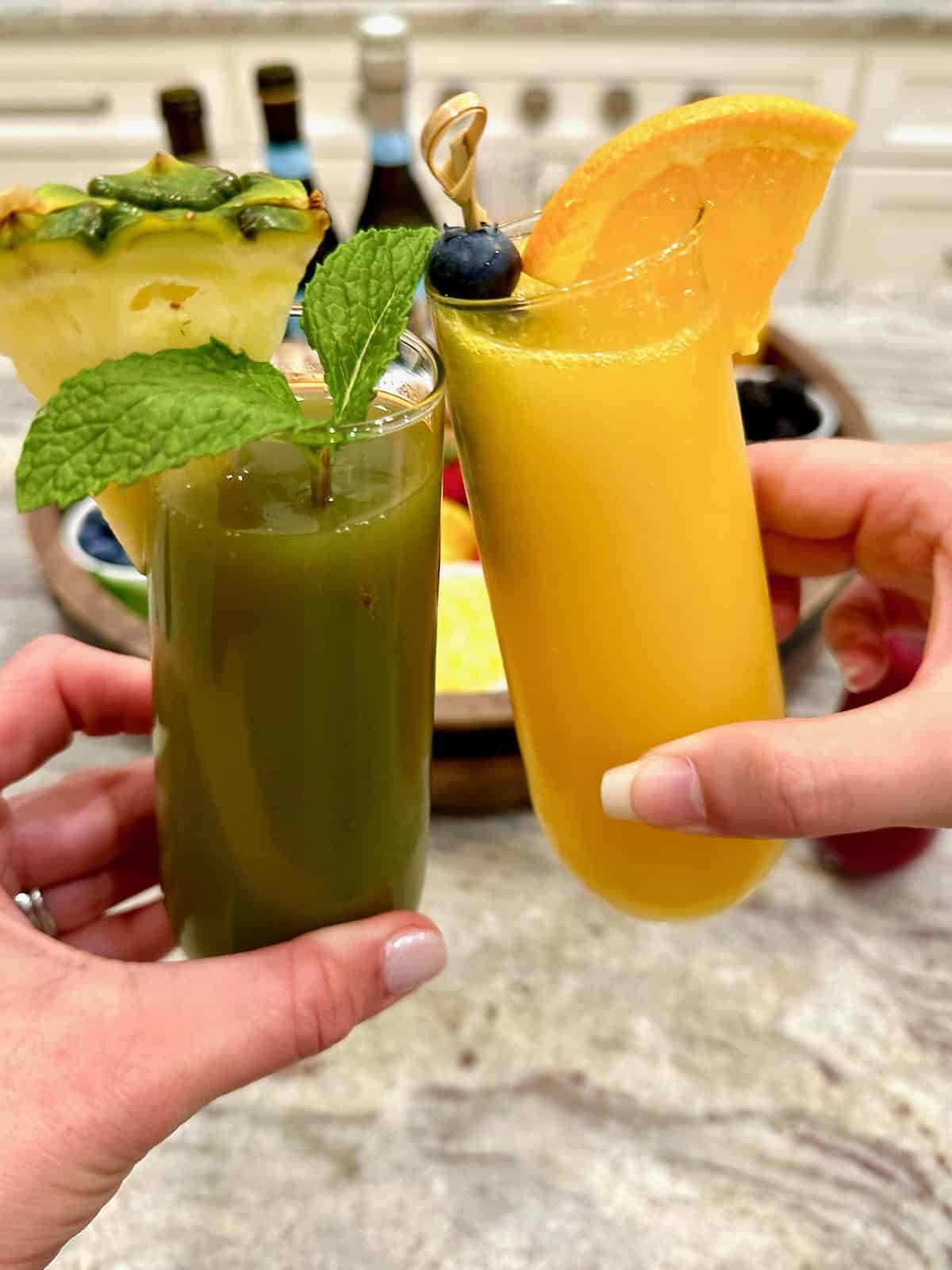 A green mimosa and an orange mimosa in front of a mimosa board.