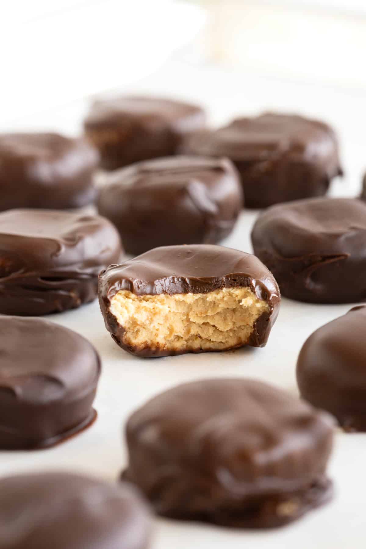 Homemade peanut butter cups piled on a parchment lined metal cooling rack.