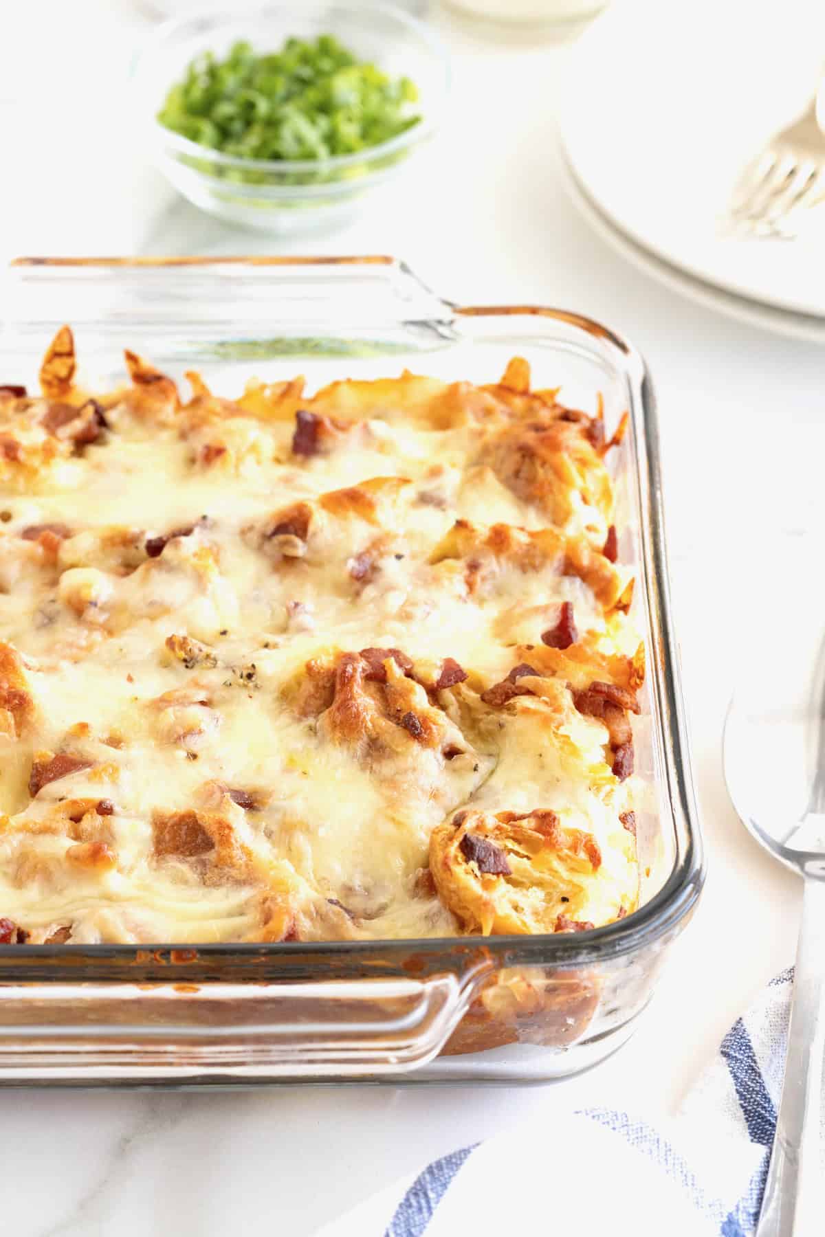 A glass baking dish of croissant breakfast casserole.