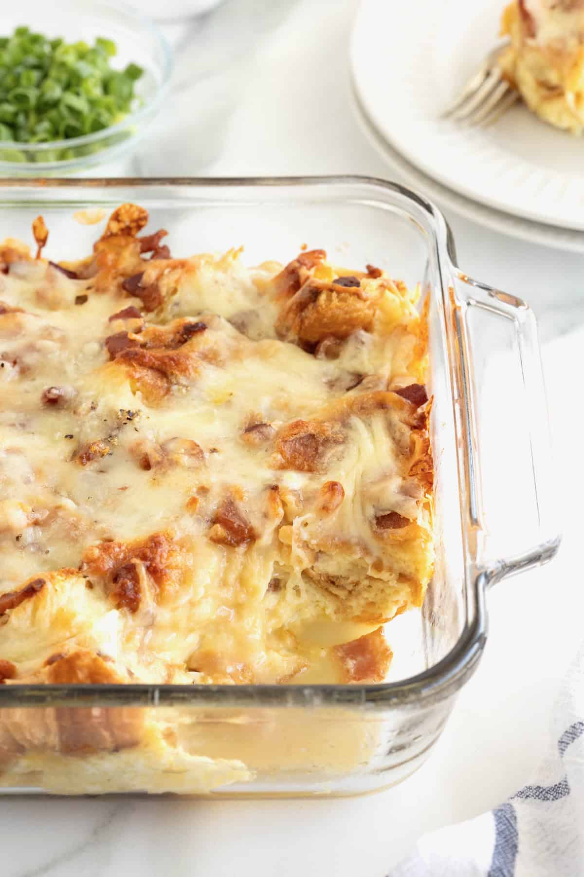 A glass baking dish of croissant breakfast casserole.