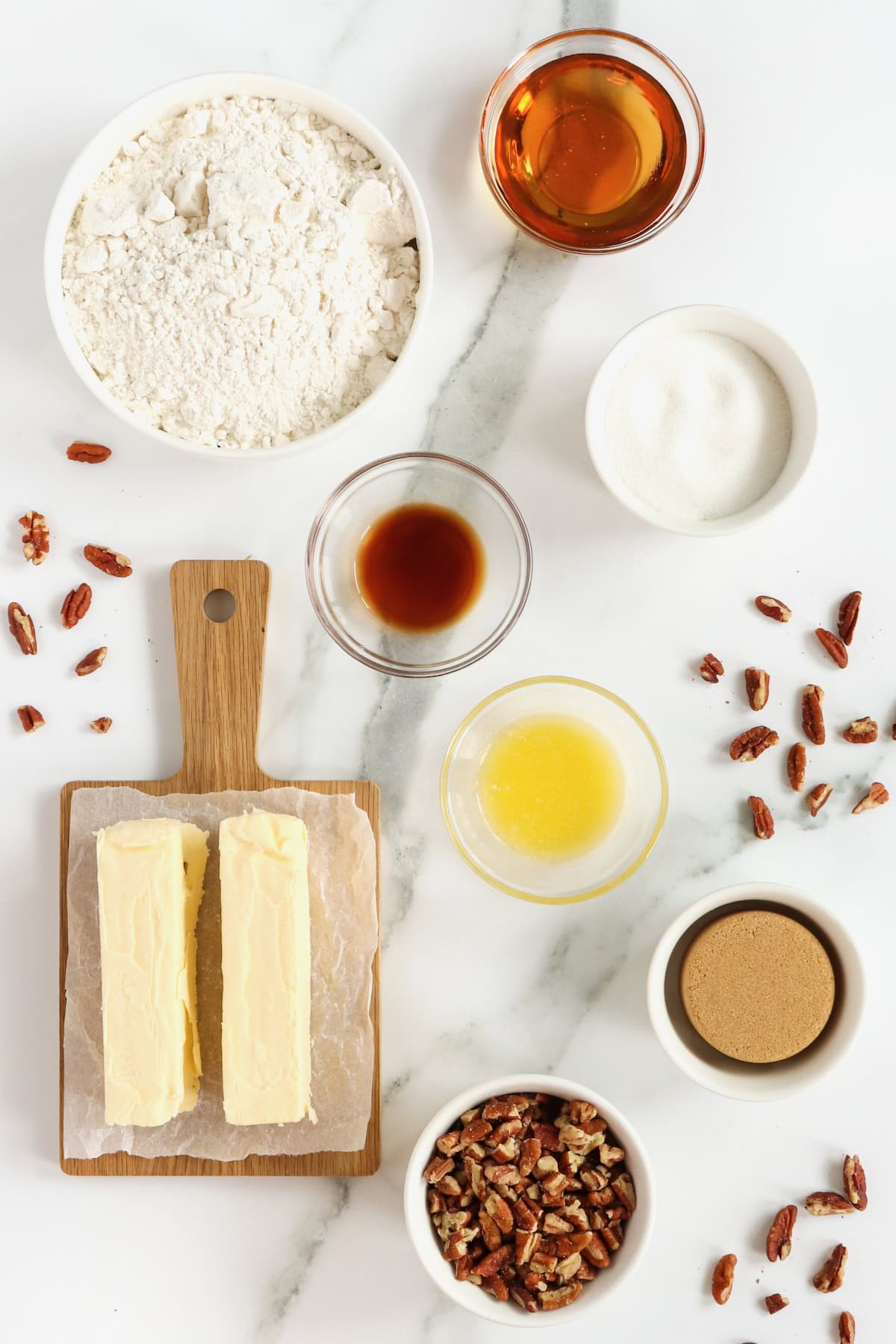 Ingredients to make Pecan Pie Thumbprint Cookies on a white marble counter.