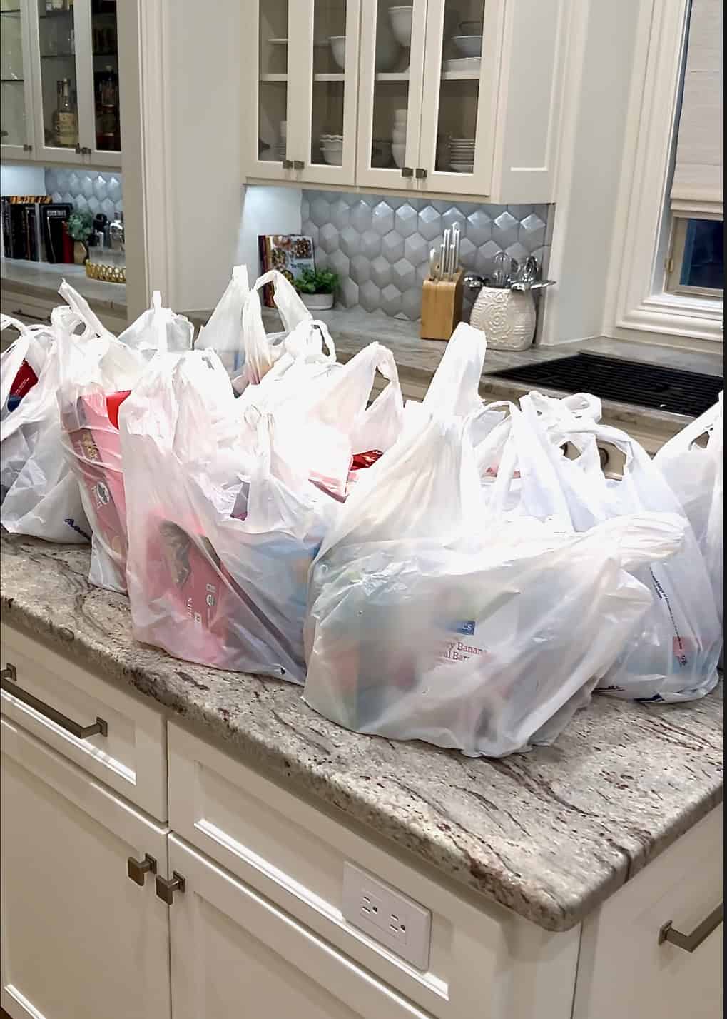 Plastic shopping bags on a gray and brown marble counter.